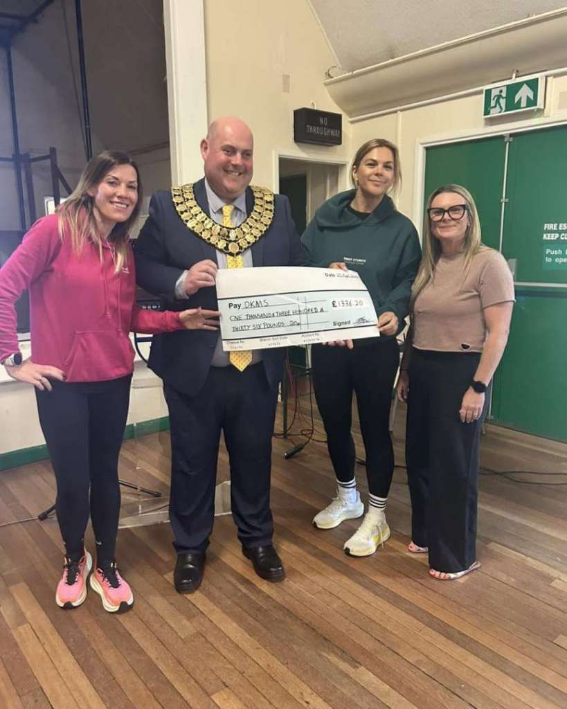 Town Mayor issuing charity cheque to DKMS 